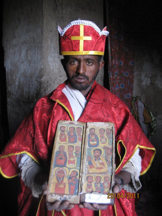 An orthodox christian holy book in Ge'ez, an an ancient Ethiopian south semitic language held up by a priest in Lalibela.